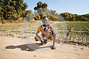 African Black Boy Proudly Sits in front of Agriculture Camp in Bamako, Mali