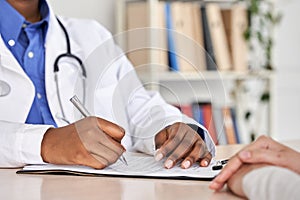 African black doctor consult woman patient filling medical form at appointment.