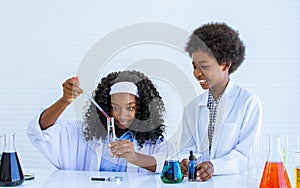 African black girl and boy studying science and making experiment in laboratory with fun, happiness at school. Education and