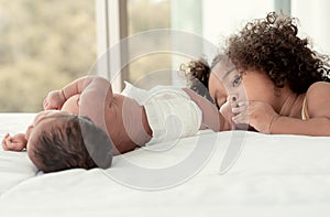 African black little girl kissing her brother& x27;s foot