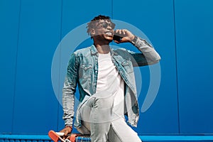 African black man sitting on a shopping cart talking on the phone, making a phone call