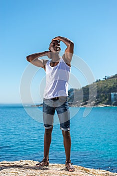 African black man wearing white vest and blue short jeans