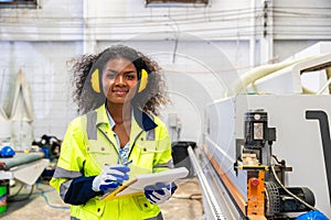 African black women worker work with wood cutter machine furniture factory industry with safety suit