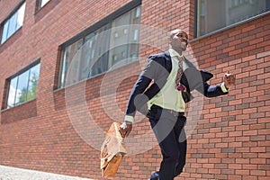 African black young businessman running in a city