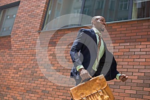 African black young businessman running in a city