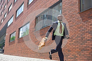 African black young businessman running in a city