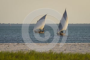 African boats sails in the ocean at sunset