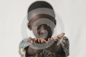 African boy holding his hands open as a concept, isolated on white and blurry background