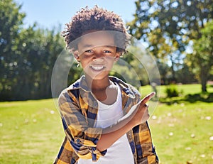 African boy, pointing and park portrait with smile, happiness or playful in outdoor sunshine. Young black child, point