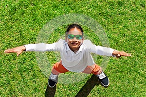 African boy in sunglasses standing on green lawn