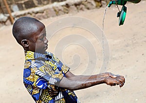 African Boy Washing Hands Properly to Avoid Contamination with Coronavirus or Virus or Bacteria photo