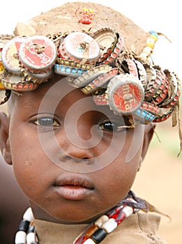 African boy wearing bottle caps