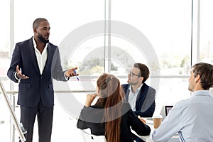 African business coach in suit giving presentation to clients