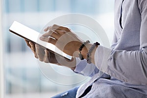 African business man holding digital tablet, close up