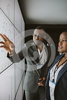 African business man pointing onto digital screen for a presentation. African businessman explaining and pointing using projection