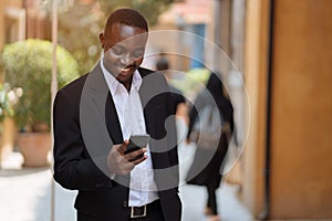 African business man using his smartphone in the city