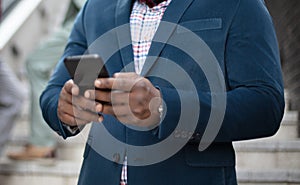 African business man using mobile outside.