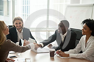 African businessman and caucasian businesswoman shaking hands at