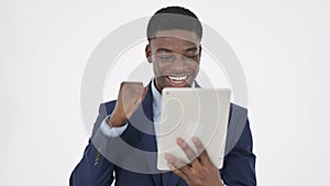 African Businessman Celebrating Success on Tablet on White Background