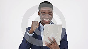 African Businessman Celebrating Success on Tablet on White Background