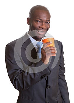 African businessman in a dark suit drinking coffee