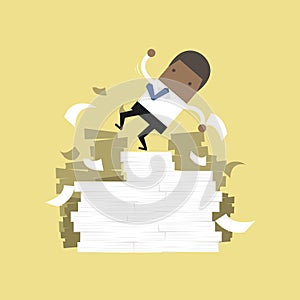 African businessman falling of paper mountain.