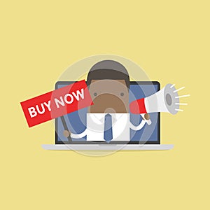 African businessman holding BUY NOW sign and megaphone in computer notebook.