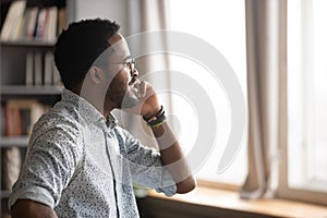 African businessman holding mobile phone talking solving issues distantly