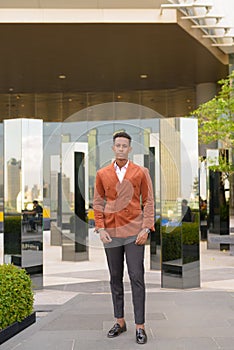 African businessman outdoors in city full length shot