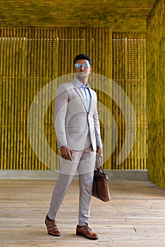 African businessman outdoors walking and looking stylish and cool full length shot