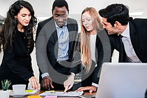 African businessman planning and discuss with Caucasian colleagues that looking on documents at an internal business group meeting