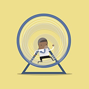 African businessman running in a hamster wheel.