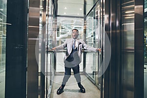 African Businessman screaming in elevator. fear claustrophobia concept