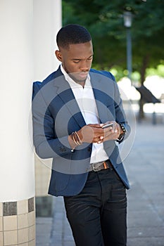 African businessman sending text message on mobile phone