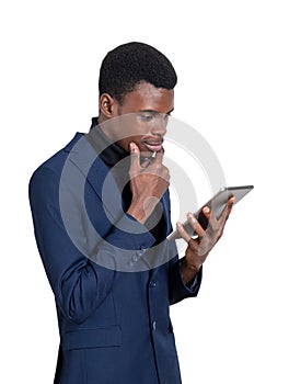 African businessman with tablet in hands, thinking. Isolated over white background