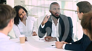 African businessman talking handshaking colleague at group meeting negotiations