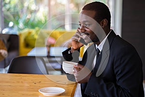 African Businessman Using smarphone In Coffee Shop