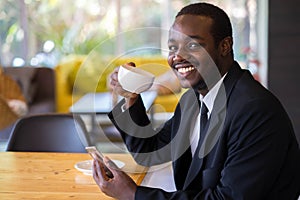 African Businessman Using smarphone In Coffee Shop