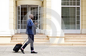 African businessman walking with bag and mobile phone