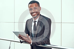 African Businessman Working on Tablet and Smiling.