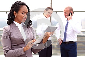 African businesswoman businessman holding a tablet in hand standing outdoor