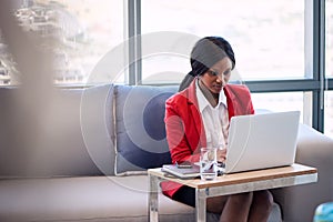 African businesswoman busy working on her notebook in business lounge