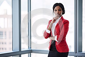 African businesswoman looking into camera confidently while wearing red blazer