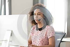 African call center operator in wireless headset talking using computer