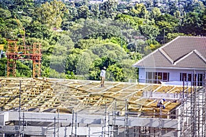 african carpenters mounting some trusses on the roof photo