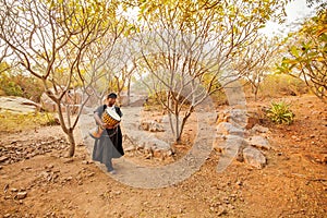 African carrying a drum in a forest