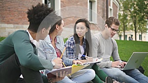 African. caucasian and asian university students doing homework together.