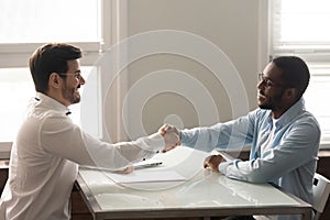 African and Caucasian businessmen shaking hands starting meeting