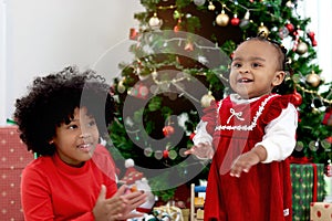 African child sister celebrating winter holiday together, little cute girl kid and her curly hair sibling playing under beautiful