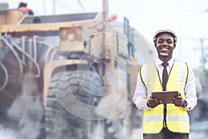 African civil engineering standing against the truck with holding tablet in hands. The technician working with use tablet for